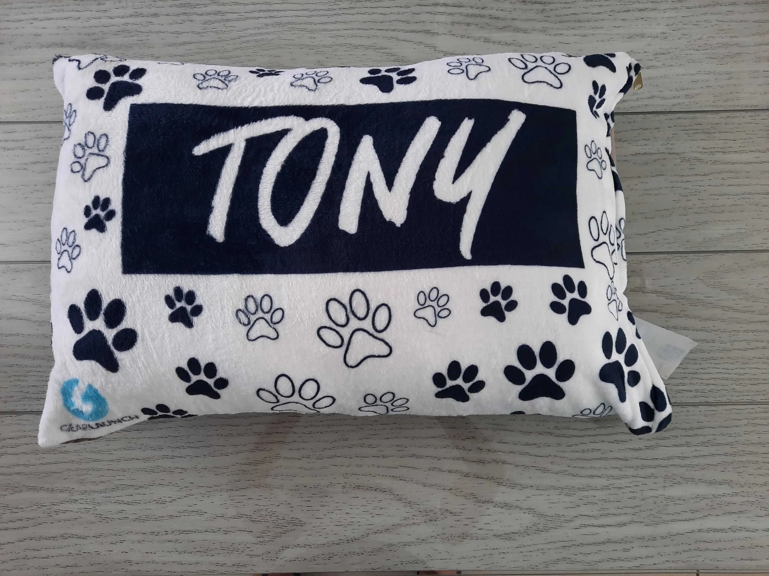 White pet bed with black paw prints and Tony printed across it