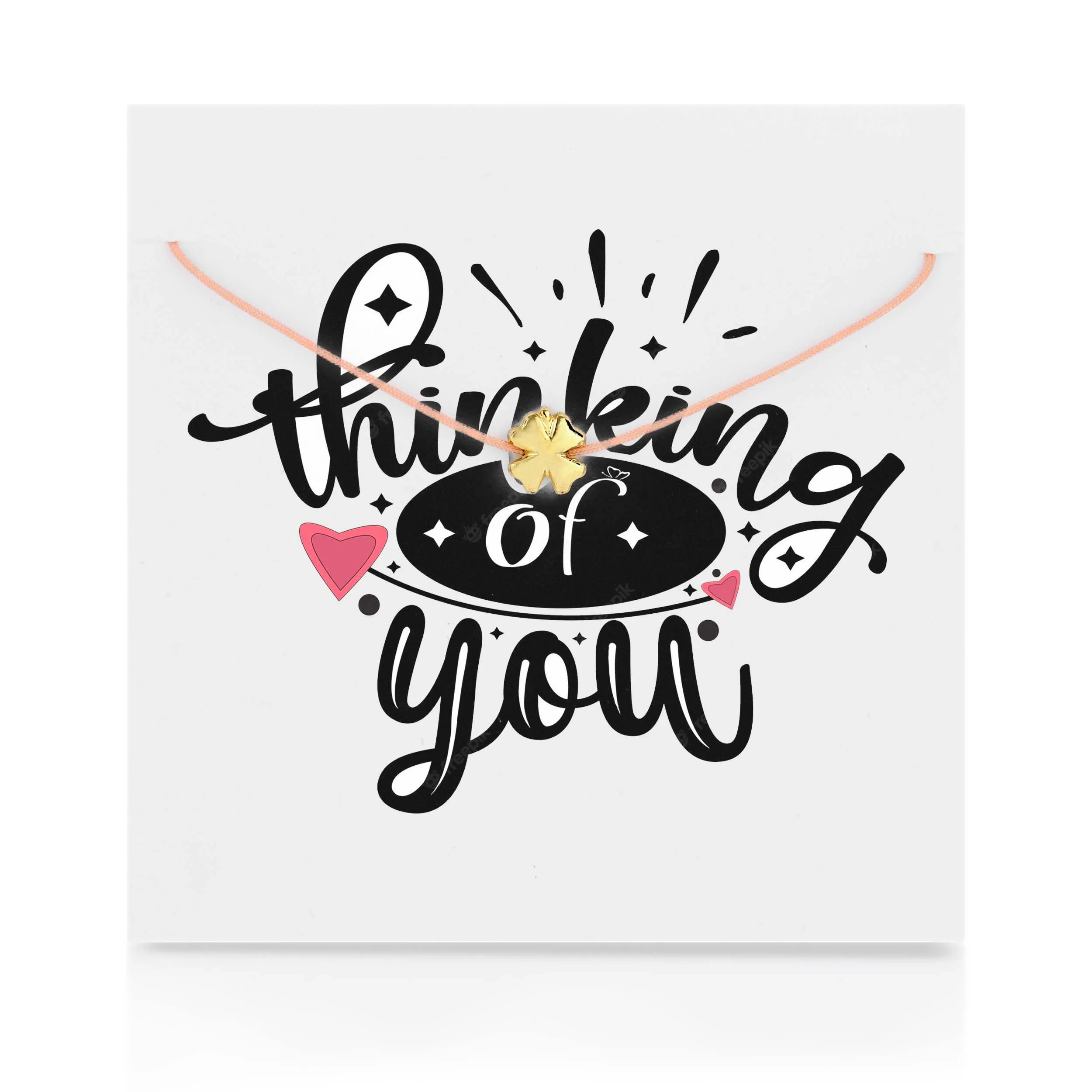 Đồ trang sức bằng thẻ với suy nghĩ của bạn trên đó với một chiếc vòng cổ cỏ ba lá vàng ở phía trước