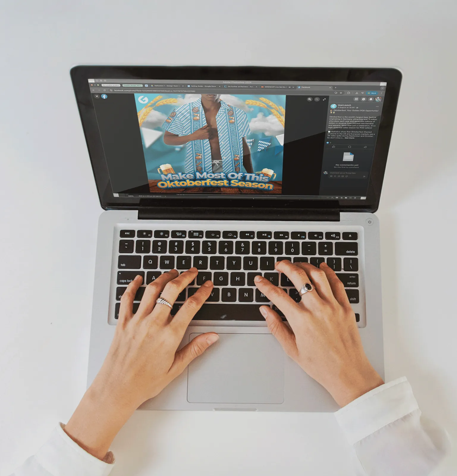 Hands typing on a laptop showing an Oktoberfest selling guide with blue and white Bavarian-pattern apparel design on screen.
