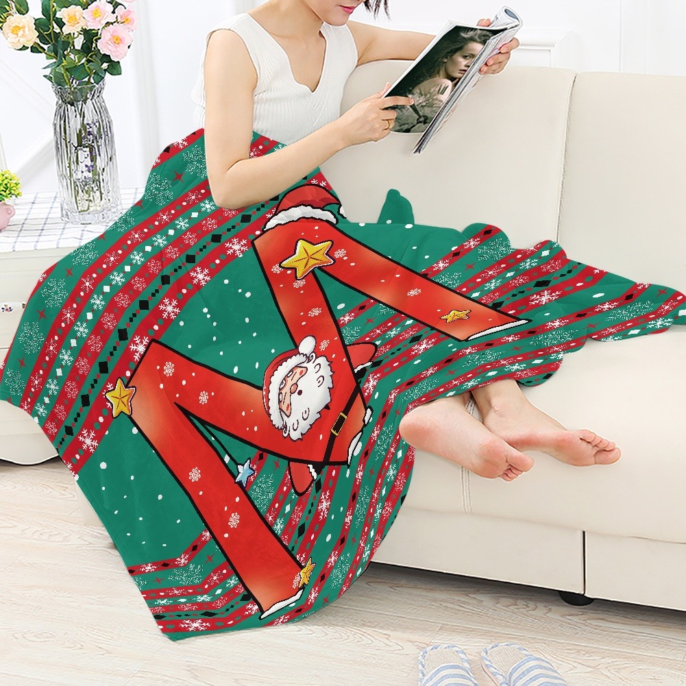 Woman reading on sofa with a green and red personalized Christmas blanket featuring Santa and festive patterns