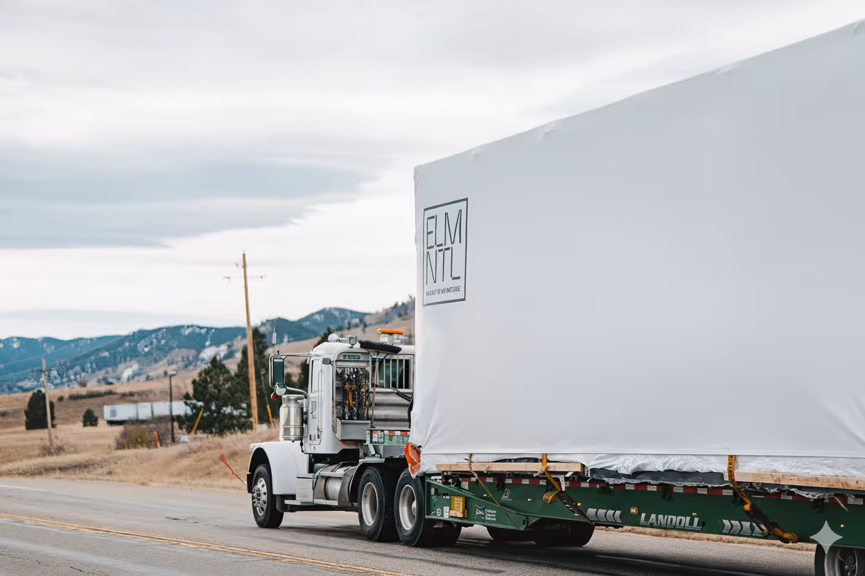 A large white truck delivering an ELMNTL Modular cabin