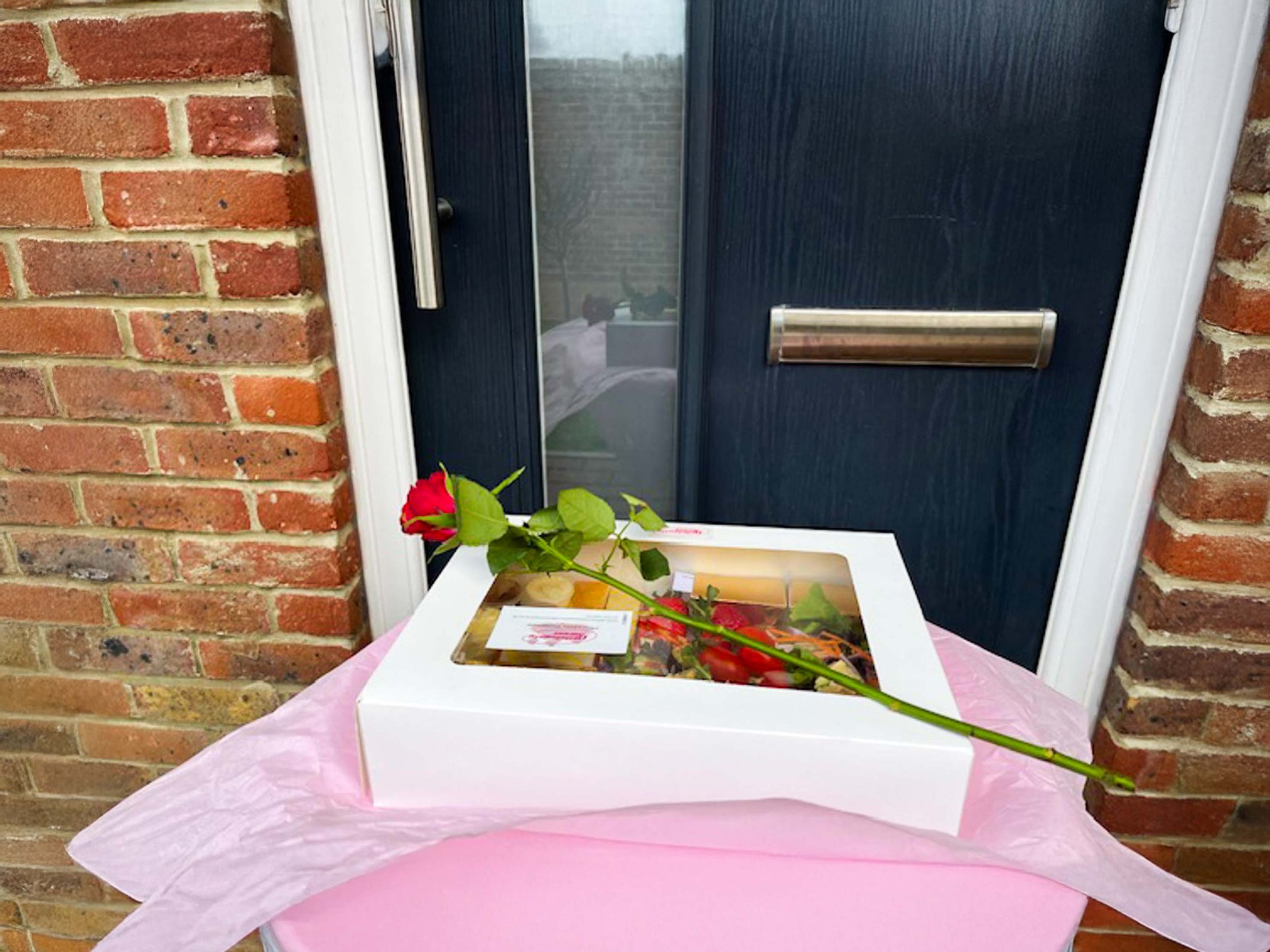 A white box with a red rose in it.