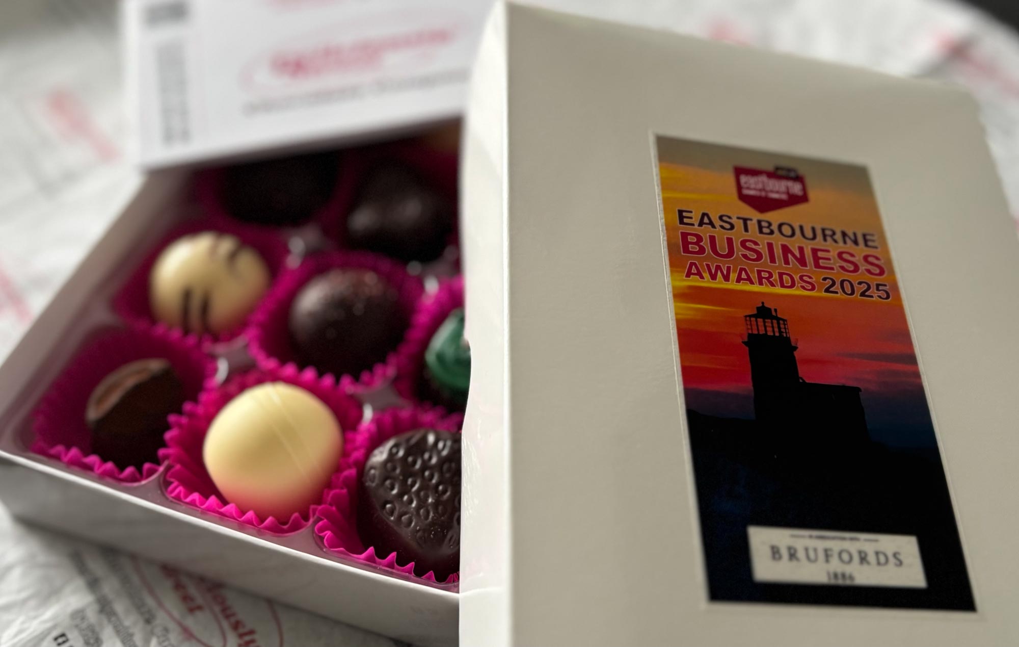 Box of assorted chocolates with a label for Eastbourne Business Awards 2025 on the lid.