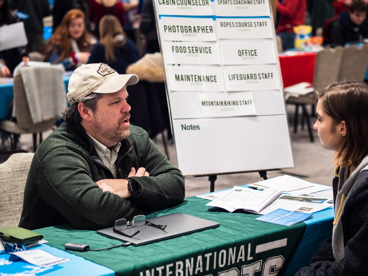 A camp director interviewing a participant at a hiring fair