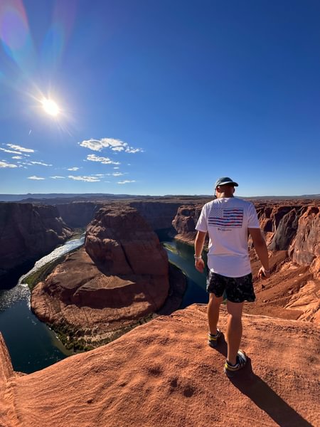 Photo of a male looking out over Horseshoe bend, USA