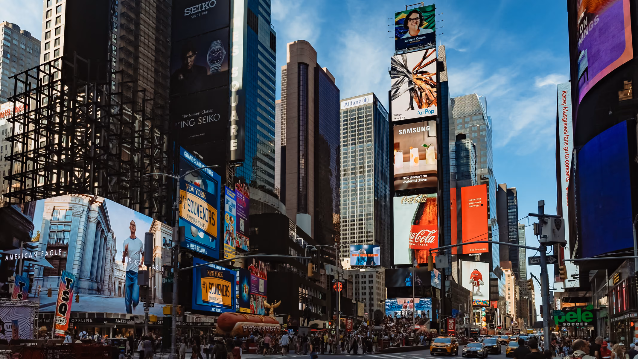 Times Square in New York City bustling with people, yellow taxis, and large digital advertisements.
