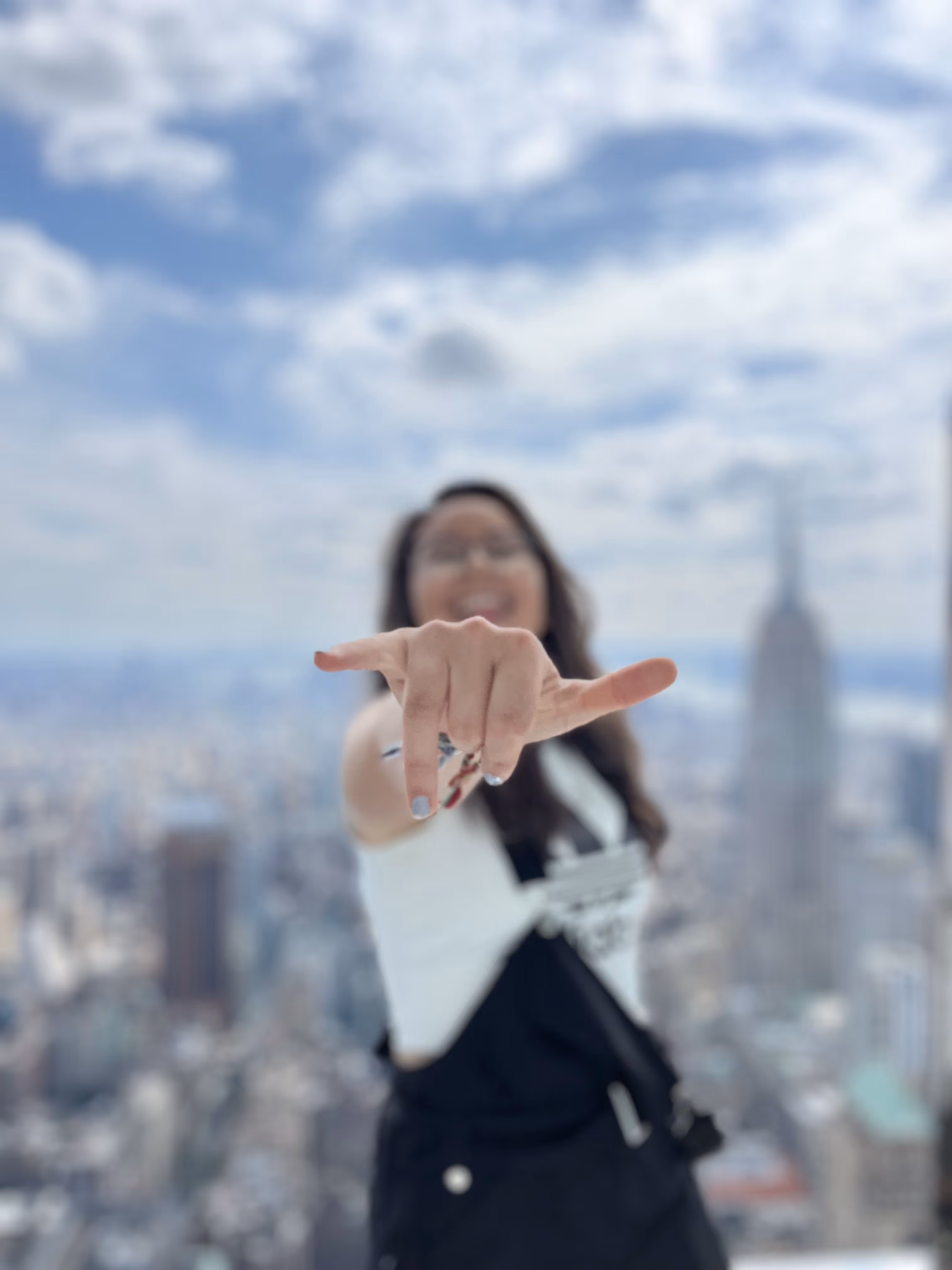 A woman posing for a photo with the New York skyline in the background