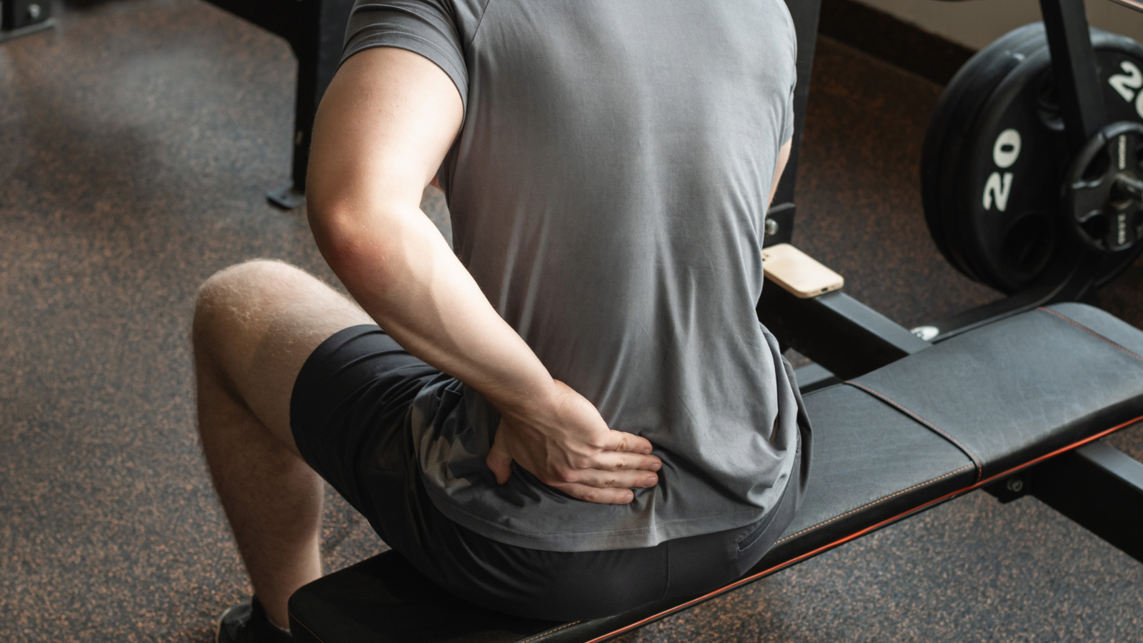 Person holding lower back in pain during gym training — lower back pain at Dan Rix Physiotherapy