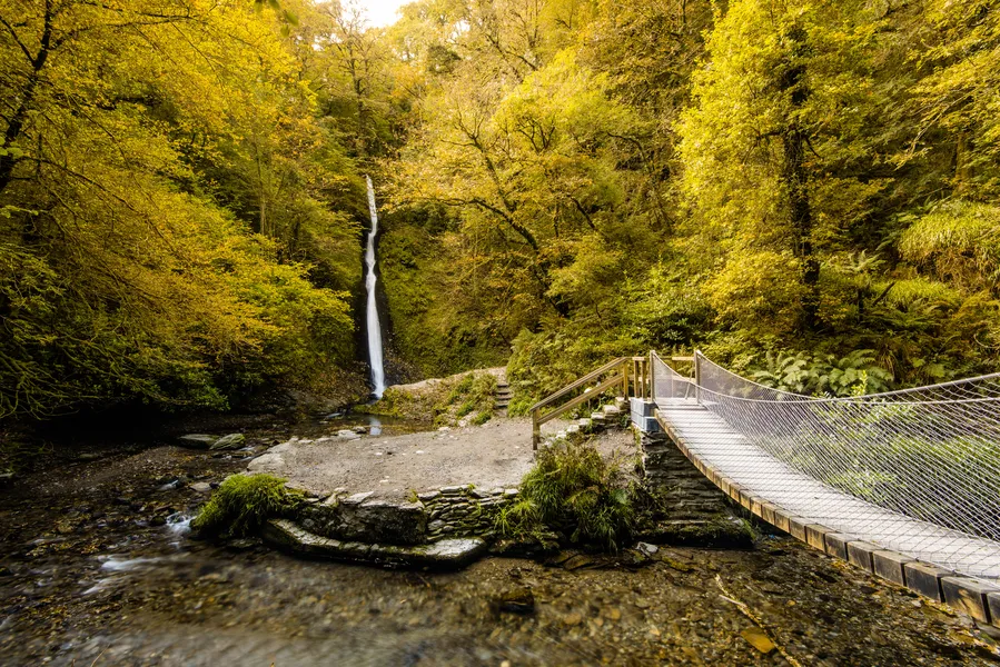 Waterfall in autumn forest in Lydford Gorge