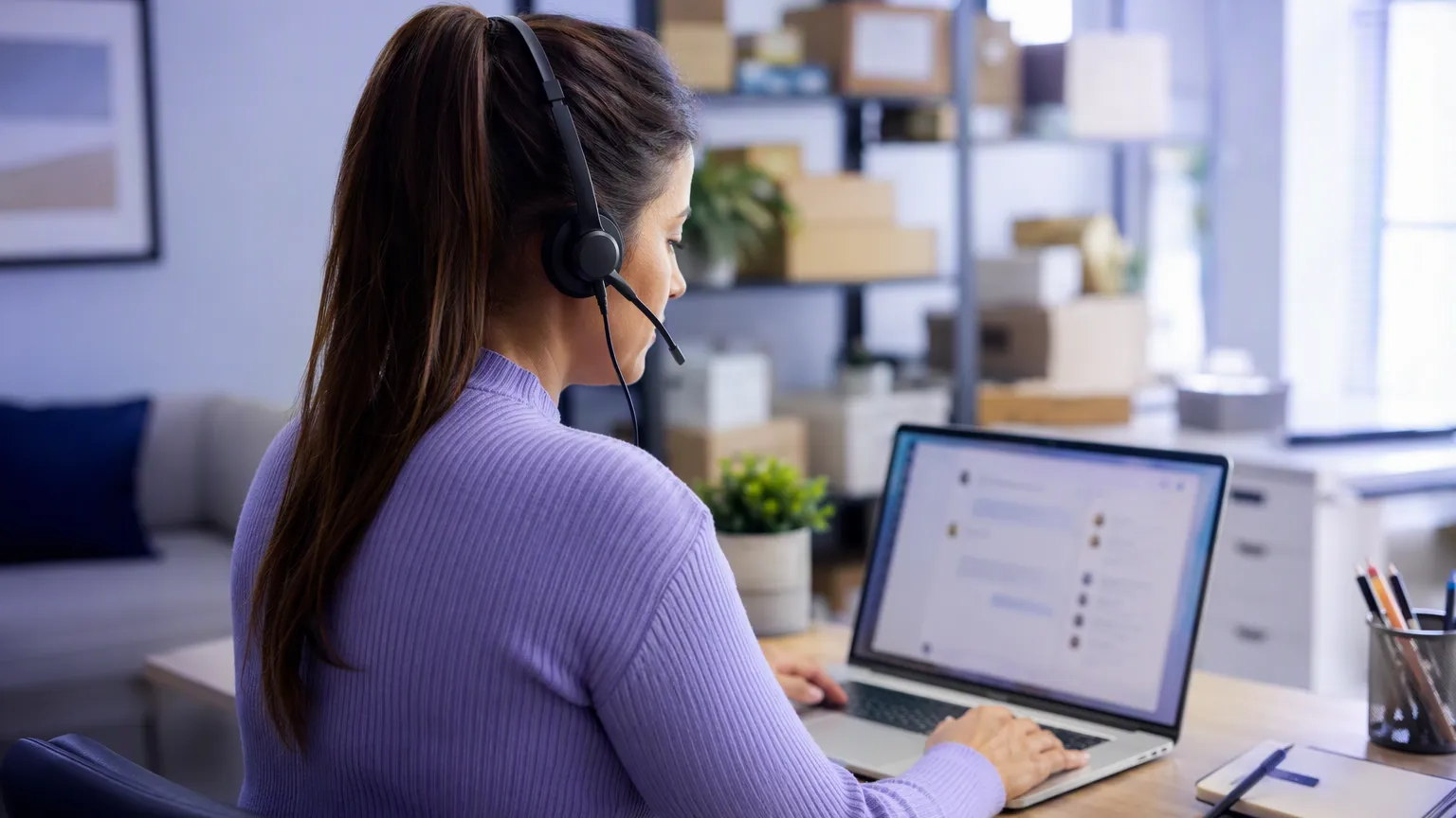 relation client chatgpt - conseillère avec casque qui répond à un client sur ordinateur
