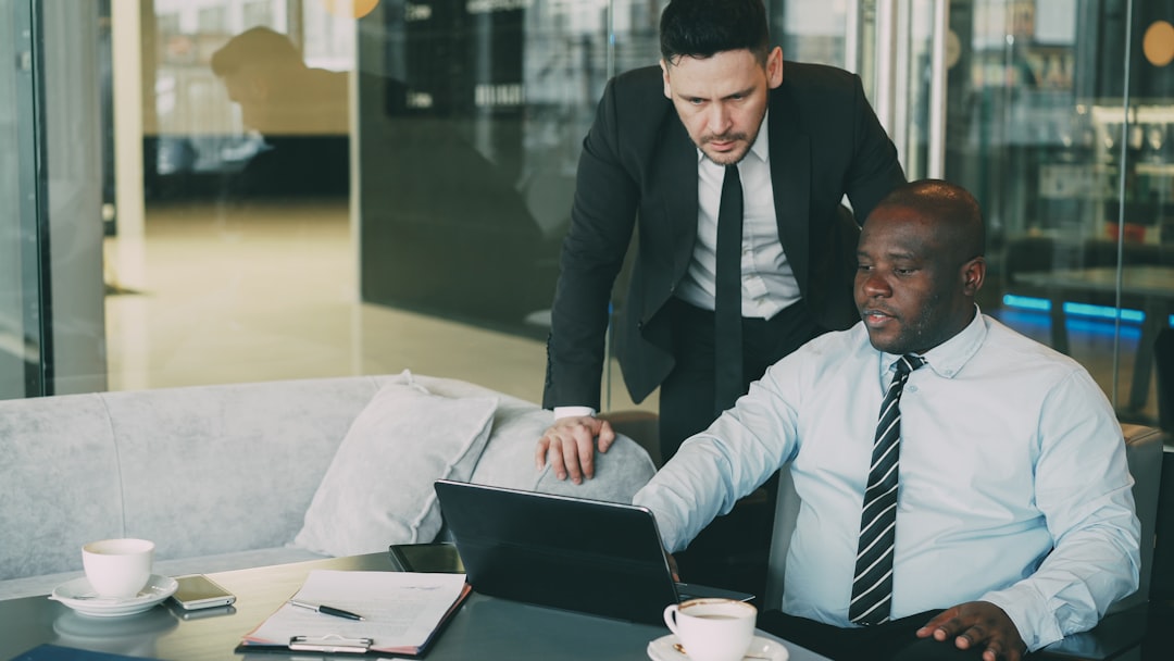 Two businessmen collaborating on a laptop in an office. for How We Streamline Client Discovery Calls: A Step-by-Step Look at Our Process
