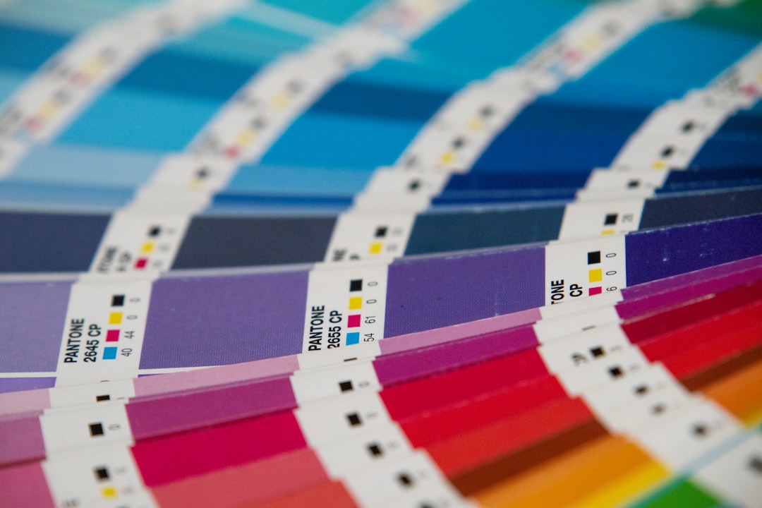 A bunch of different colors of paper on a table for The Small Business Owner's Guide to Using Canva for Professional Brand Design Without Hiring a Designer