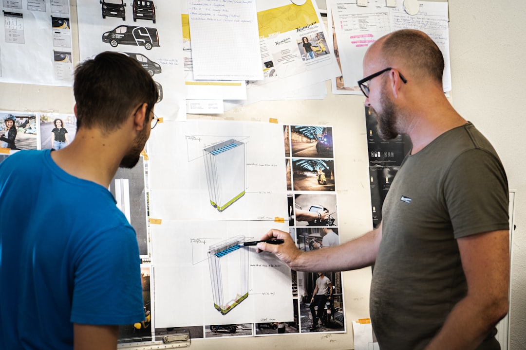Man in blue crew neck t-shirt holding white printer paper for How We Restructured Our Design Process to Deliver Projects 40% Faster Without Sacrificing Quality