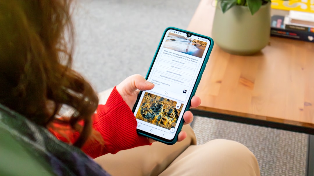 A woman sitting on a couch holding a cell phone for How a Local Coffee Roastery Increased Online Orders by 240% Through Strategic Website Redesign and User Experience Improvements