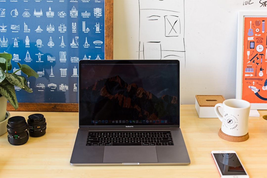 Macbook Pro on table near white mug and PRODUCT RED iPhone for How to Repurpose Your Best-Performing Social Media Content Across Multiple Platforms Without Looking Repetitive