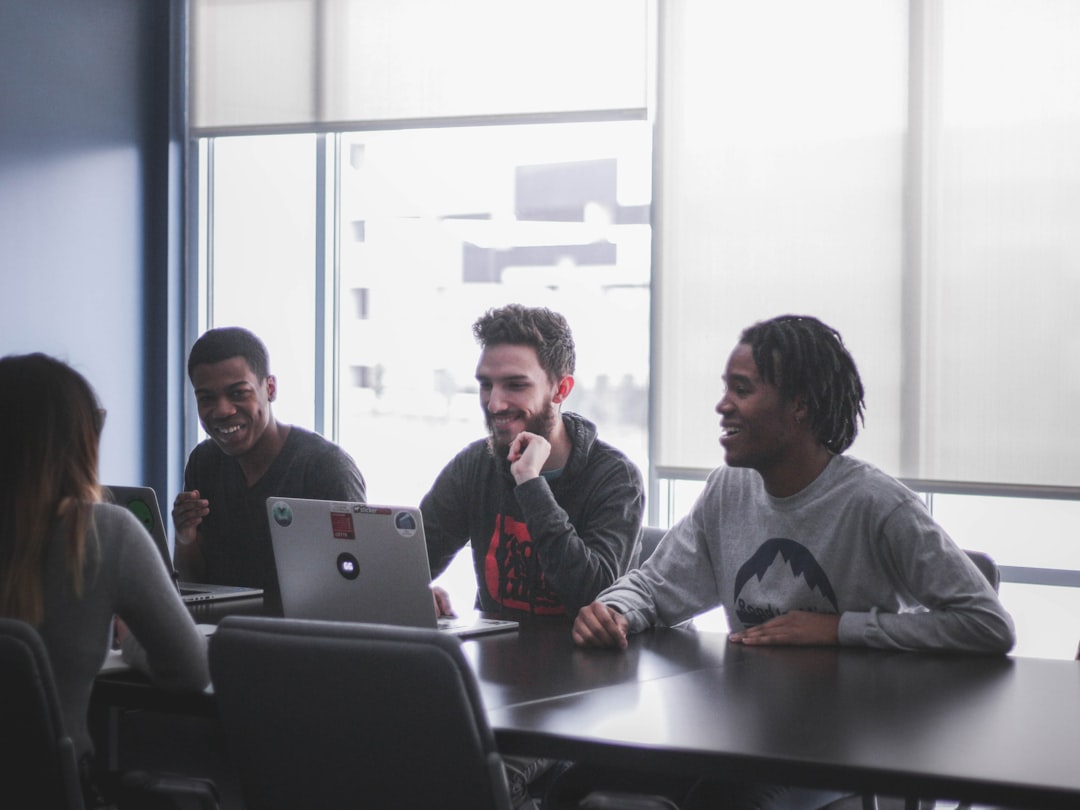 Three men facing woman while sitting in front of table for How to Create a Content Calendar That Actually Drives Small Business Growth