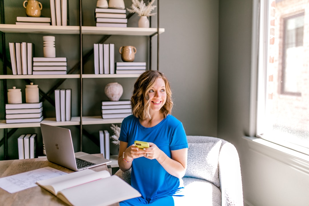 Woman in blue dress sitting at desk with laptop. for How to Create a Content Calendar That Actually Drives Customer Engagement for Your Small Business