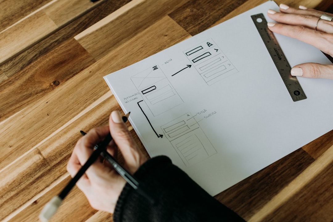 A person holding a pencil and drawing on a piece of paper for How We Redesigned Our Client Onboarding Process to Cut Project Setup Time in Half
