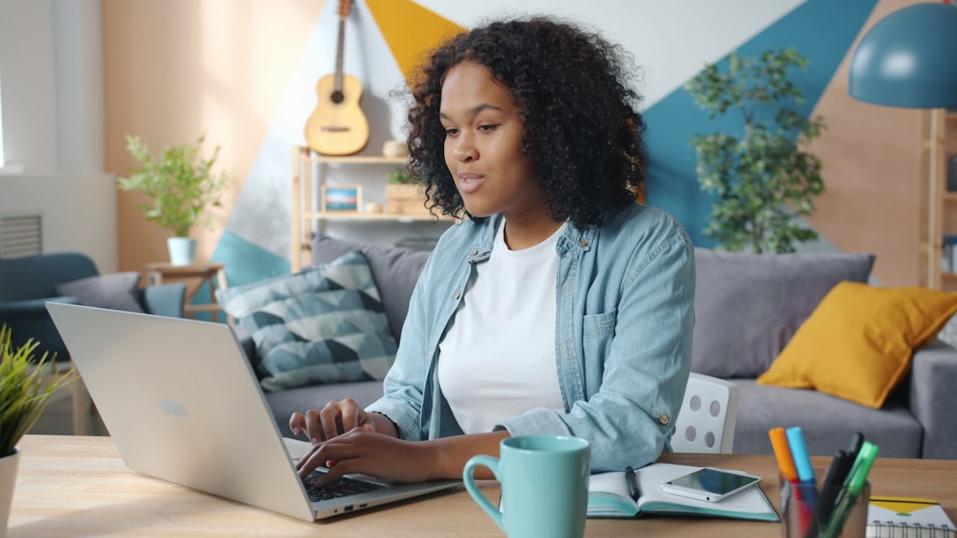 Woman working on a laptop in a cozy living room. for How to Optimize Your Google Business Profile for Local SEO and Increased Customer Traffic
