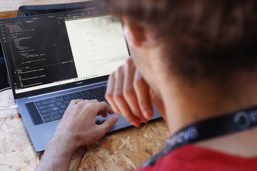 A man sitting at a table using a laptop computer for How to Choose Between Node.js and Python for Your Small Business Backend: A Practical Comparison