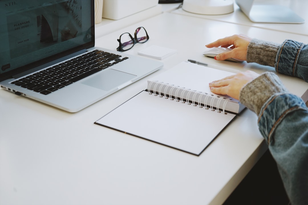 Person touching white spiral notebook for # 5 Free Keyword Research Tools Small Businesses Can Use Instead of Expensive SEO Software