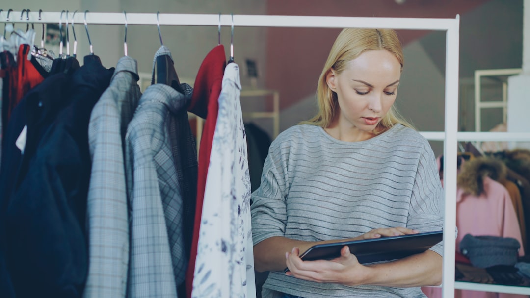 Woman reviews inventory in a clothing store. for How to Optimize Your Google Business Profile for Local Search Rankings