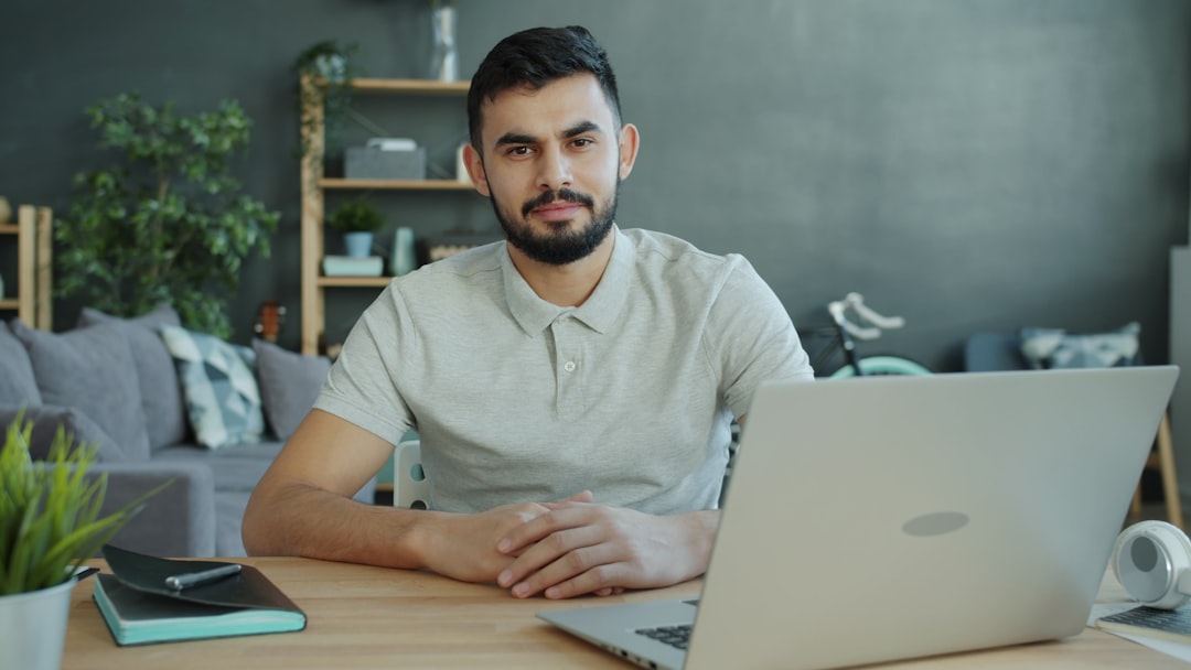 Man sitting at desk with laptop in living room for "5 Critical Elements to Include When Redesigning Your Small Business Website for Better Conversions"