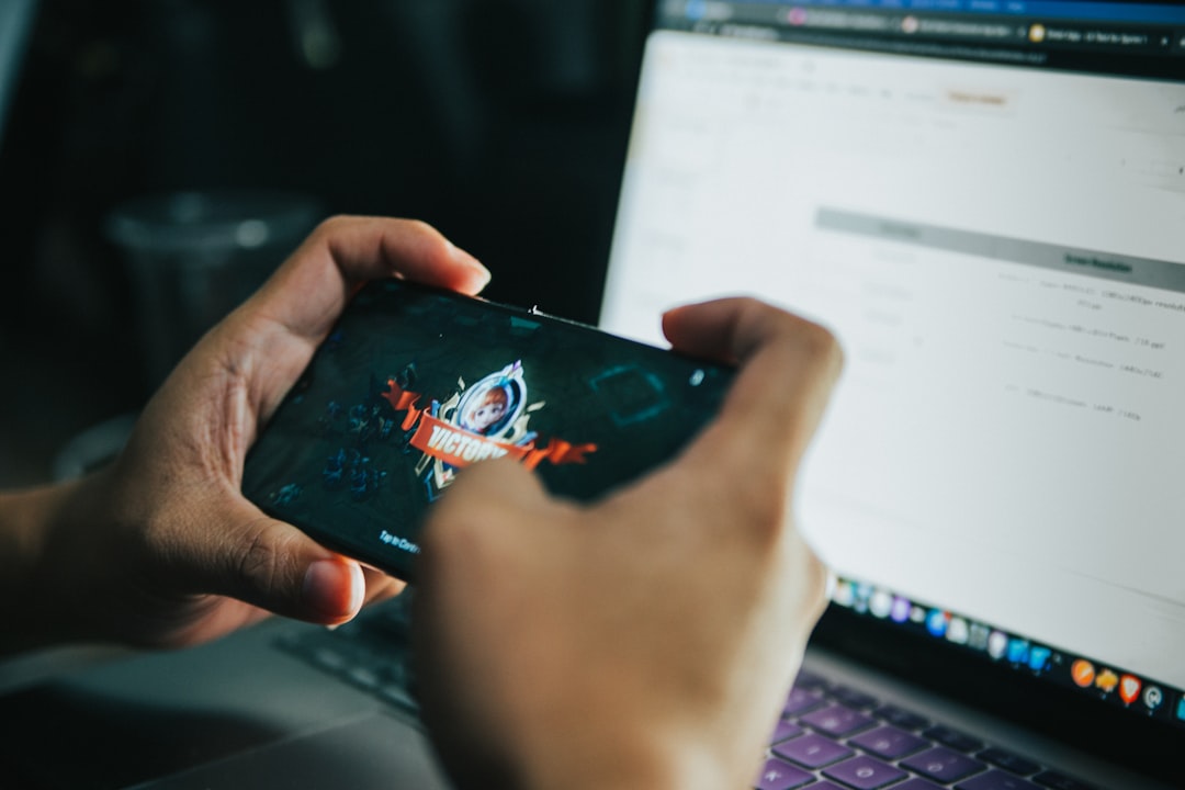 Person holding smartphone playing mobile legensds for "5 Critical Elements to Include When Redesigning Your Small Business Website for Better Conversions"