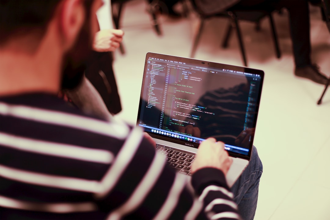 A man sitting in front of a laptop computer for "How to Choose Between Node.js and PHP for Your Small Business Website: A Practical Comparison Guide"