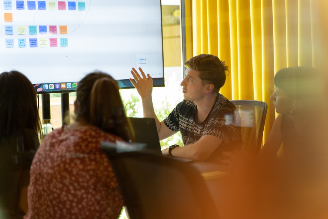 A man giving a presentation to a group of people for "How to Choose Between Monolithic and Microservices Architecture: A Guide for Growing Businesses"