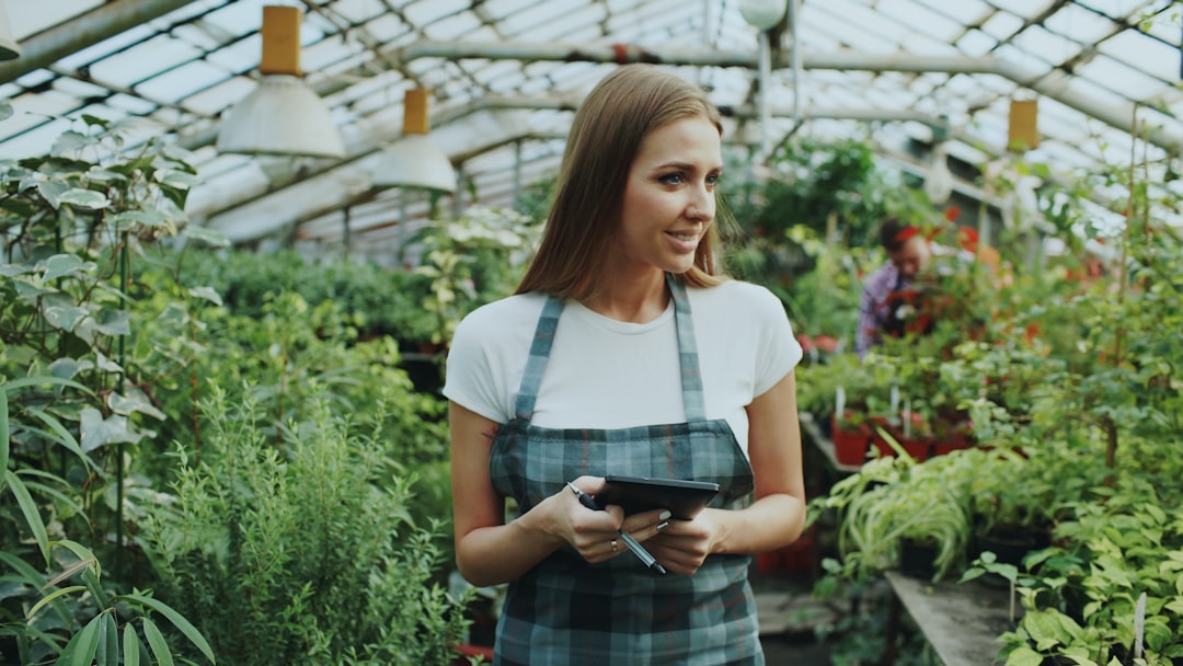 Woman working in a greenhouse surrounded by plants for How Progressive Web Apps Can Replace Native Mobile Apps for Small Businesses Without Breaking Your Budget