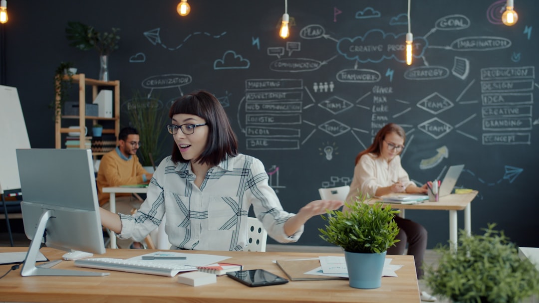 People working in a modern office with chalk drawings for "How to Use Asana to Manage Client Projects Without Overwhelm: A Step-by-Step Guide for Small Agencies"