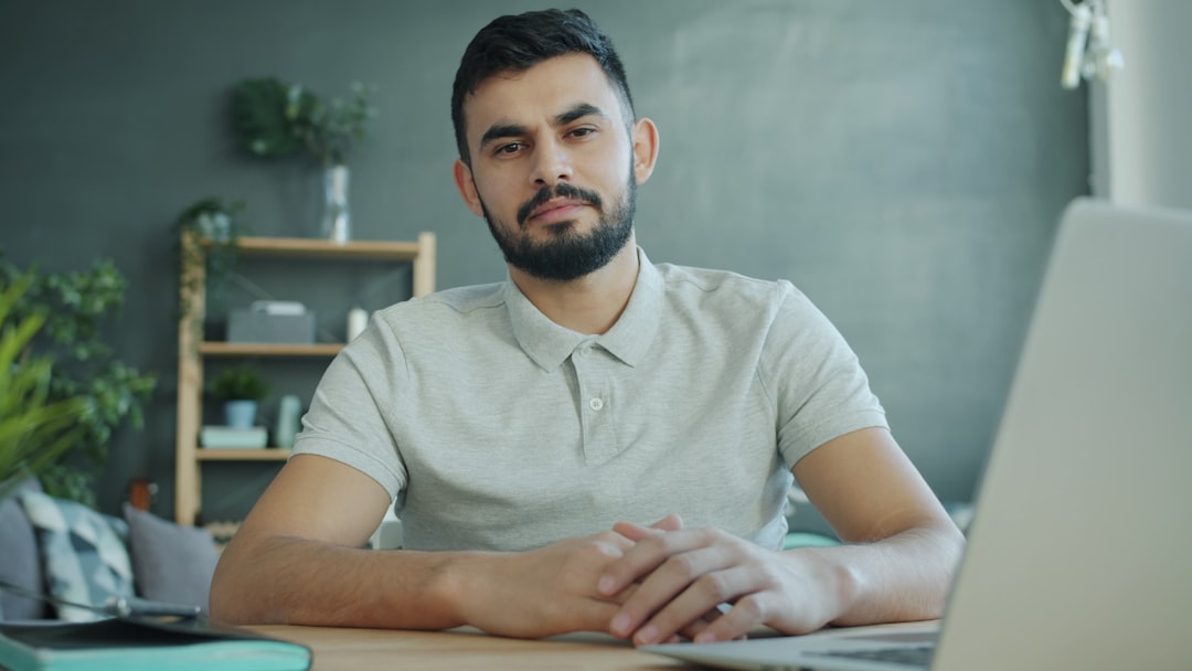Man sitting at a desk with a laptop for "5 Minimalist Web Design Principles That Actually Increase Conversions for Small Businesses"