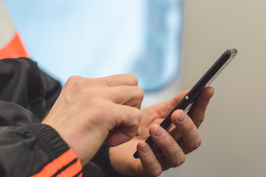 Person in black and orange long sleeve shirt holding black pen for How to Design Mobile-First Forms That Increase Conversion Rates for Small Business Websites