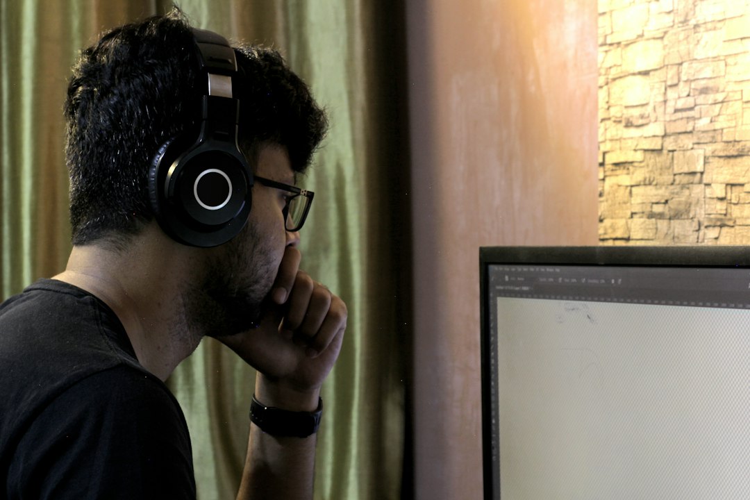 Man in black crew neck t-shirt wearing black headphones for "How to Choose Between Figma, Adobe XD, and Sketch: A Small Business Owner's Comparison Guide"