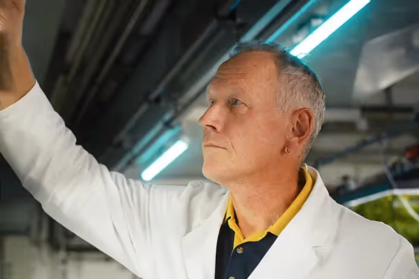 Ein Wissenschaftler im weißen Kittel arbeitet konzentriert im Labor – Szene aus einer professionellen Filmproduktion oder einem Werbefilm, die Forschung, Innovation und Präzision in moderner Technologie eindrucksvoll inszeniert.