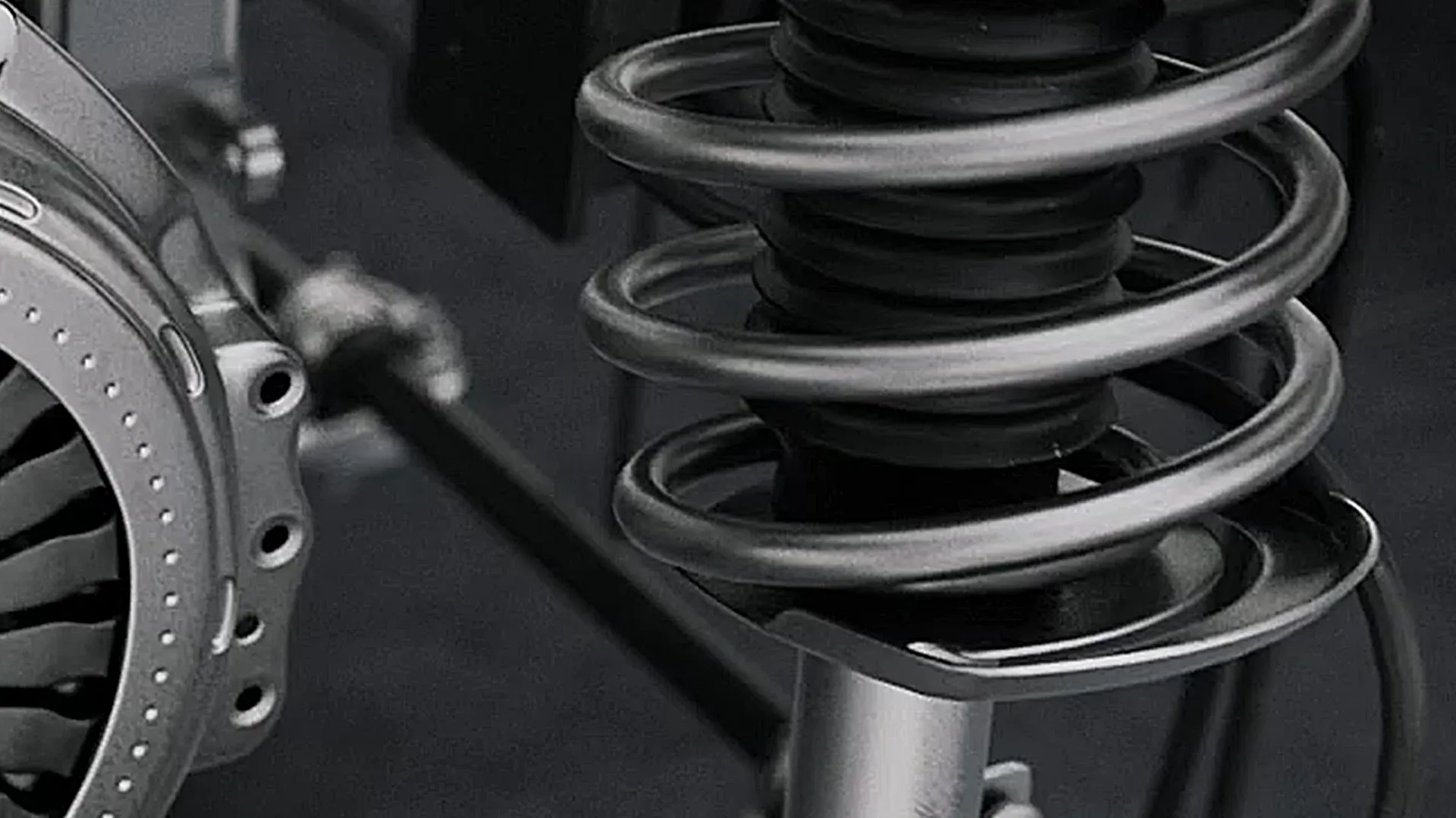 Detailreiche 3D-Animation einer Fahrwerksfeder mit Dämpfungssystem. Szene aus einem technischen Produktvideo oder Werbefilm, der Präzision, Ingenieurtechnik und hochwertige Fahrzeugkomponenten visuell darstellt.