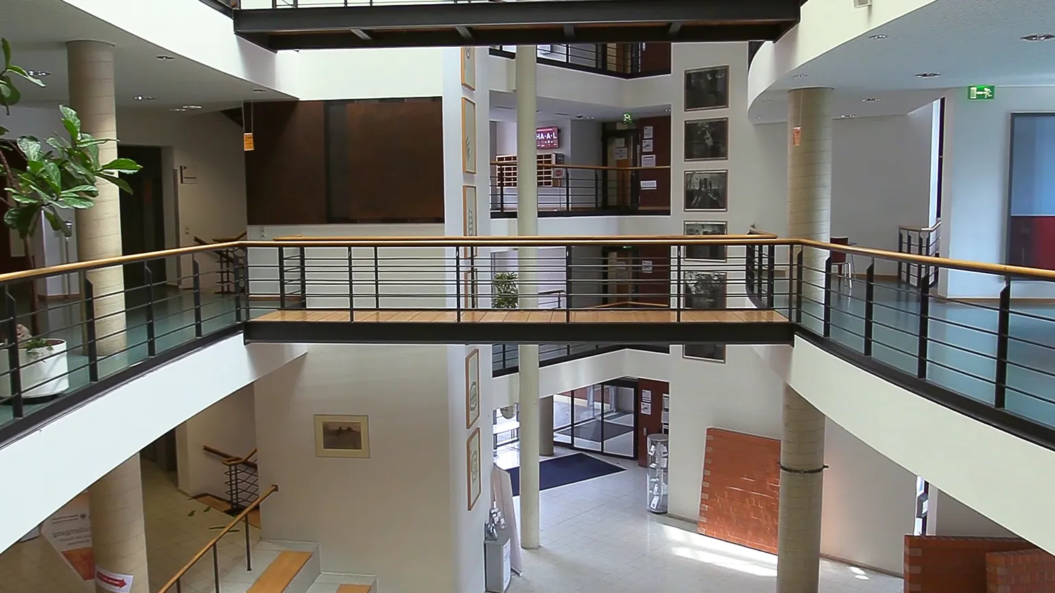 Recruitingfilm Szene: Modernes Atrium einer Hochschule mit offenen Galerien, hellen Wänden und Kunstwerken – visuelle Darstellung von Architektur, Bildung und Campusleben in hochwertiger Filmproduktion und Recruitingfilm.