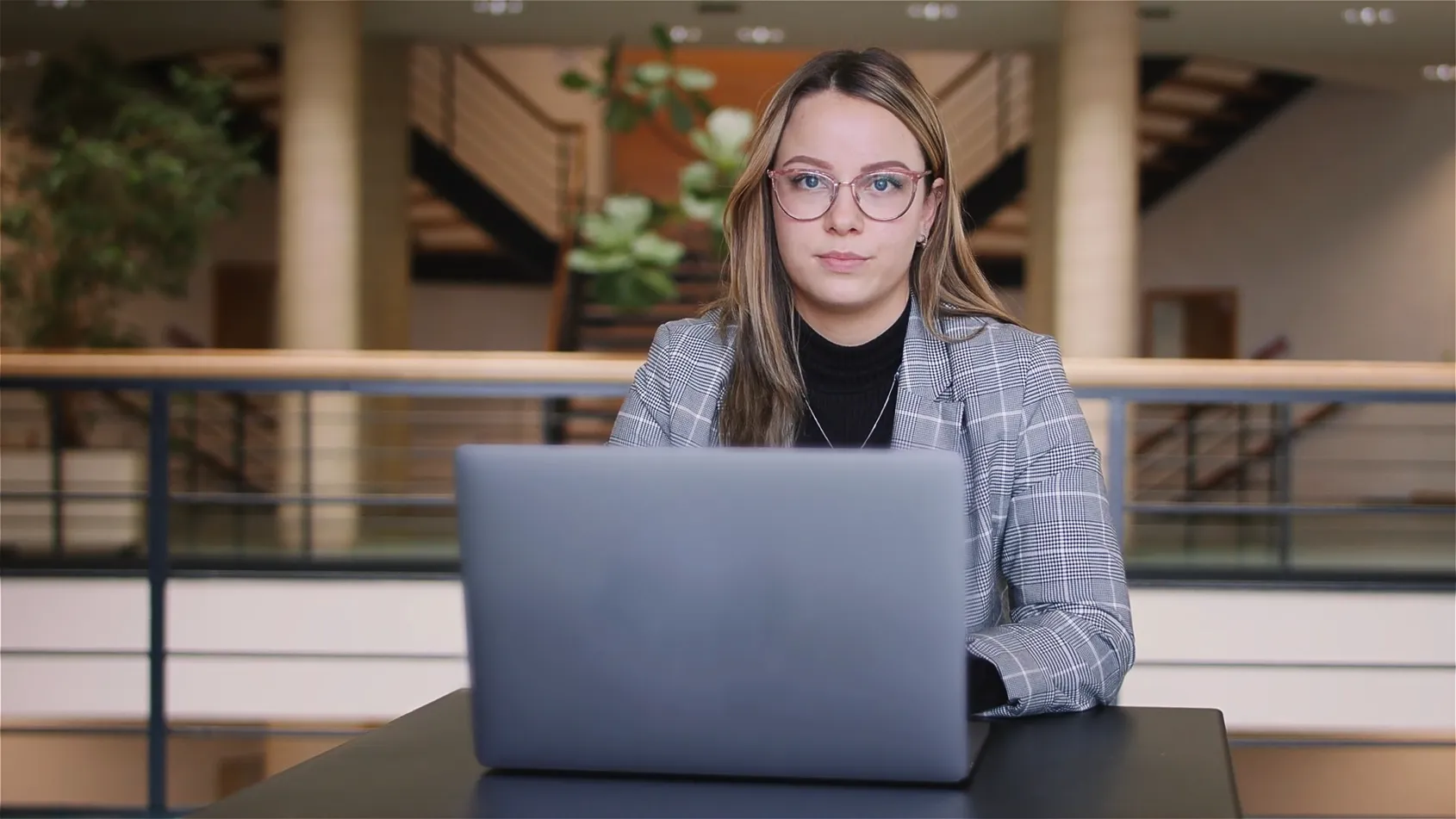 Recruitingfilm Szene: Studentin arbeitet mit Laptop im modernen Gebäude der Hochschule des Bundes und studiert Cyber-Sicherheit – authentische Darstellung von Bildung, Digitalisierung und Lernen in professioneller Filmproduktion.