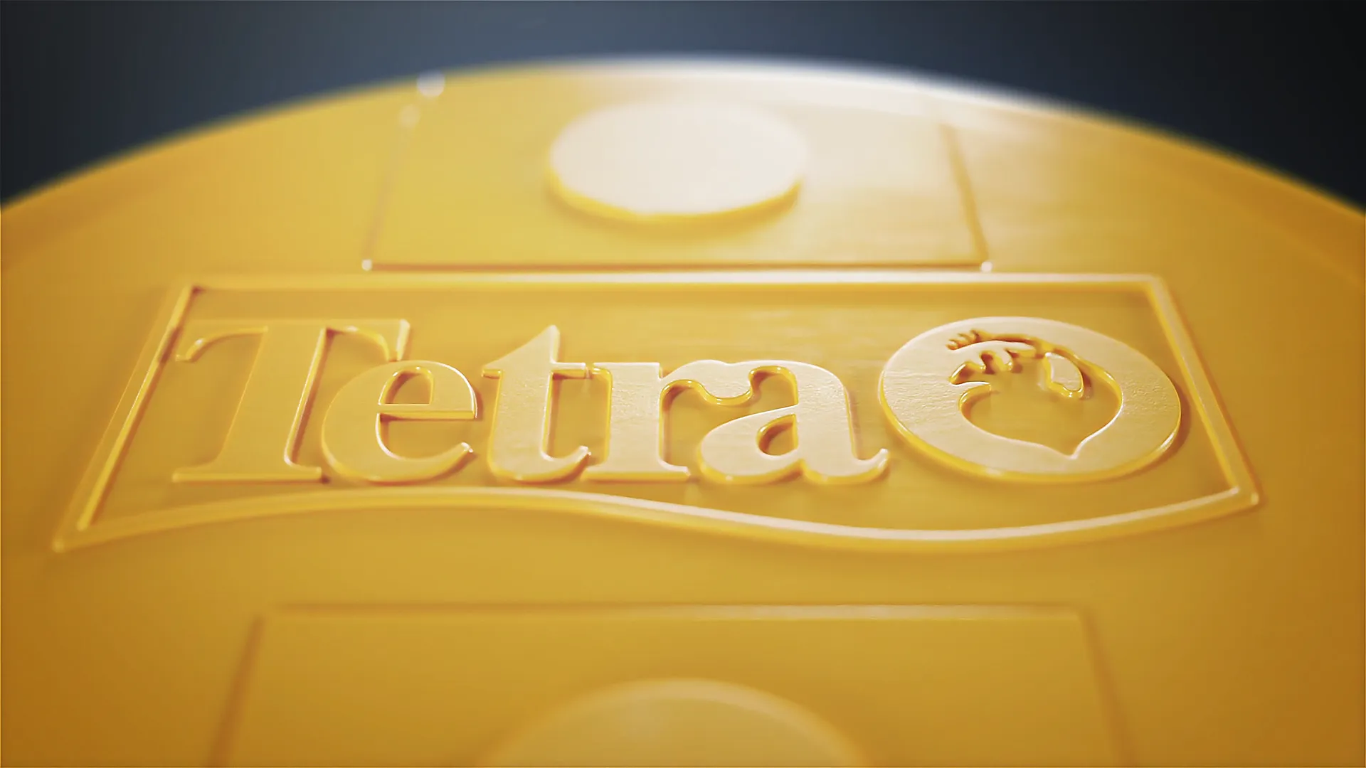 3D-Visualisierung der TetraPRO Produktdose, goldgelber Deckel mit eingraviertem Tetra-Logo und Fischsymbol, im Fokus glänzende Oberflächen und strukturierte Details.