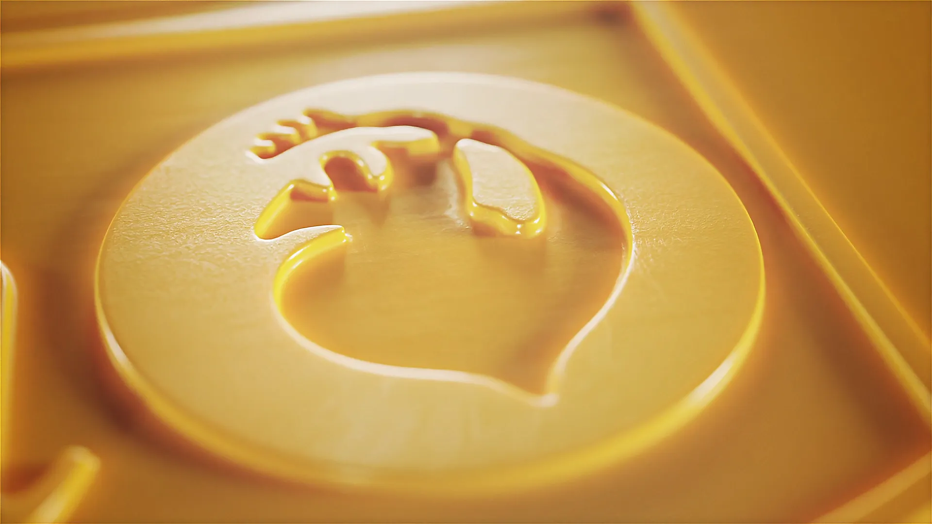 Detailaufnahme einer goldgelben 3D-Prägung mit Fischsymbol im Relief, plastisch hervorgehoben durch weiche Lichteffekte – hochwertige Markeninszenierung.