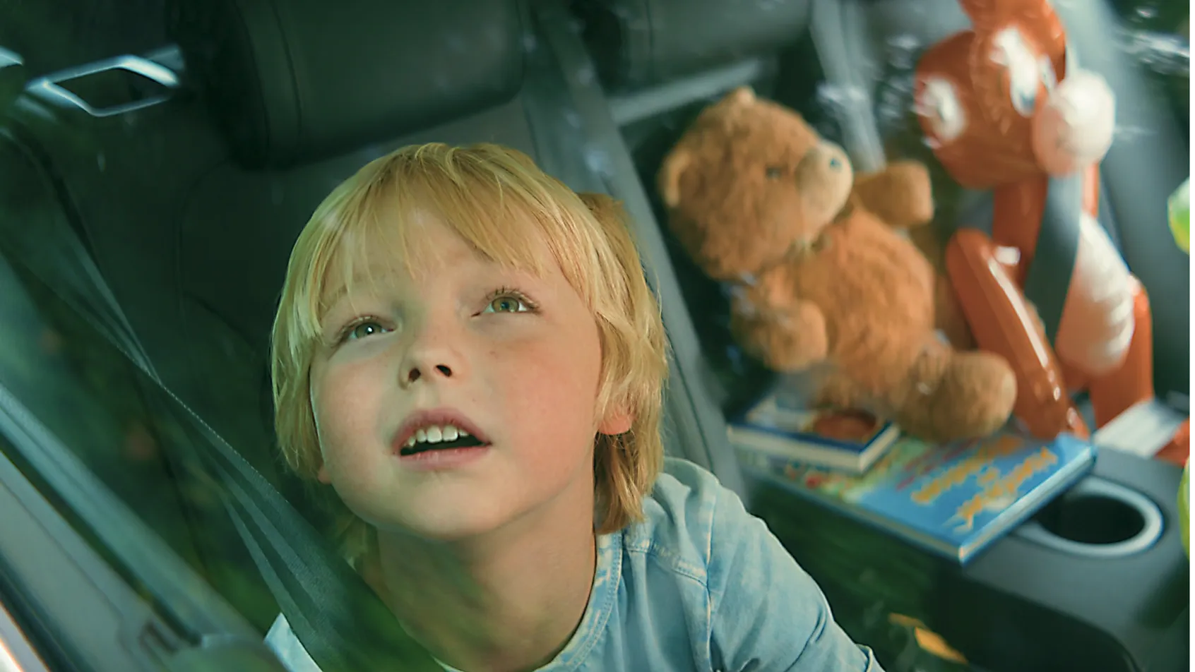 Junge sitzt auf Rücksitz schaut aus dem Autofenster mit Stofftieren FEBI Werbefilm.