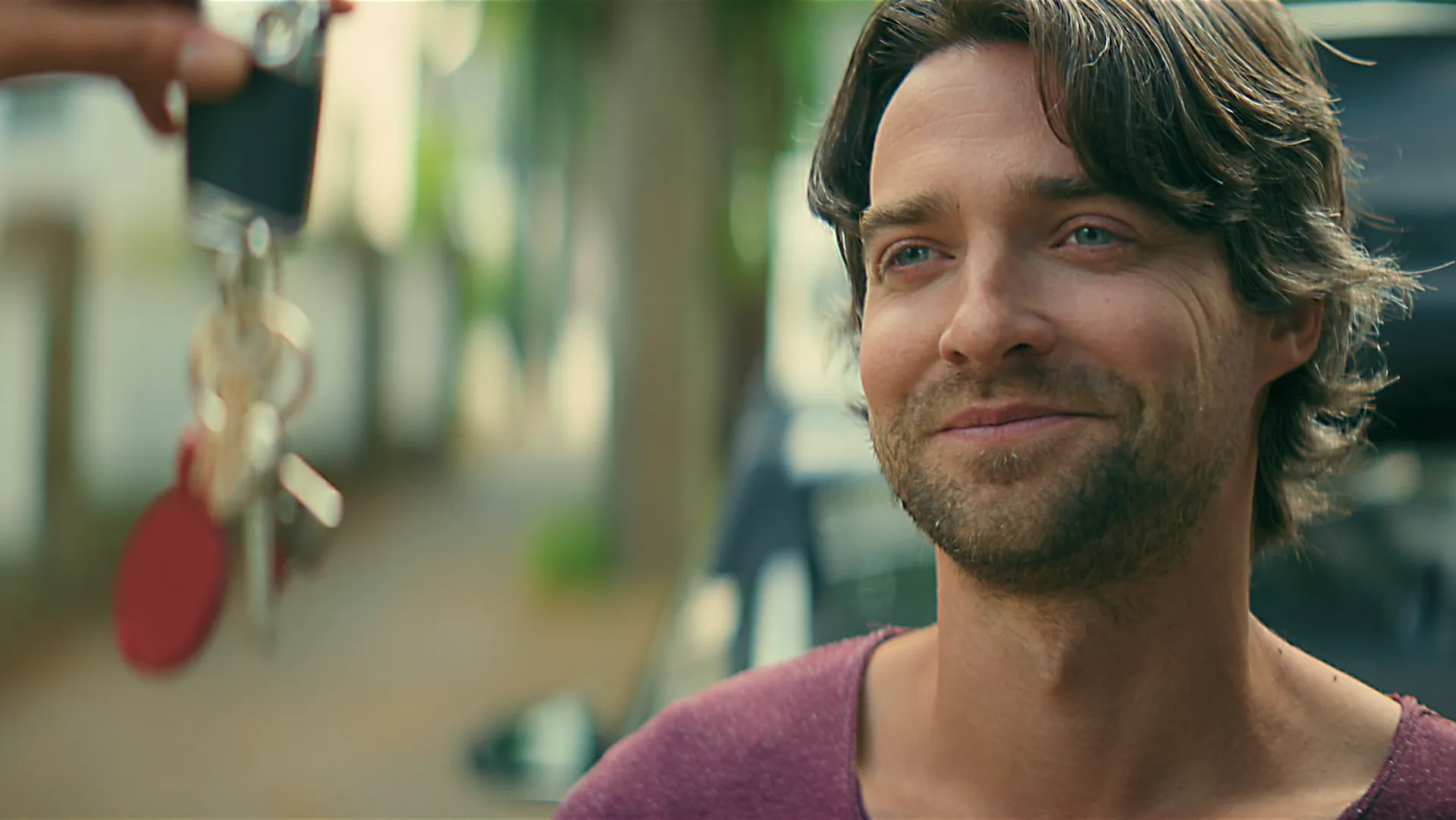 Mann nimmt Autoschlüssel entgegen und lächelt FEBI Servicefilm.