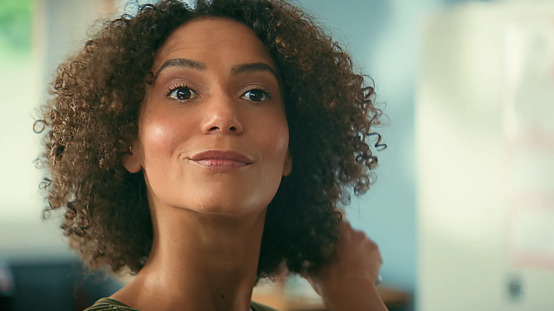 Frau mit lockigen Haaren lächelt zufrieden FEBI Werbefilm Kundenszene.