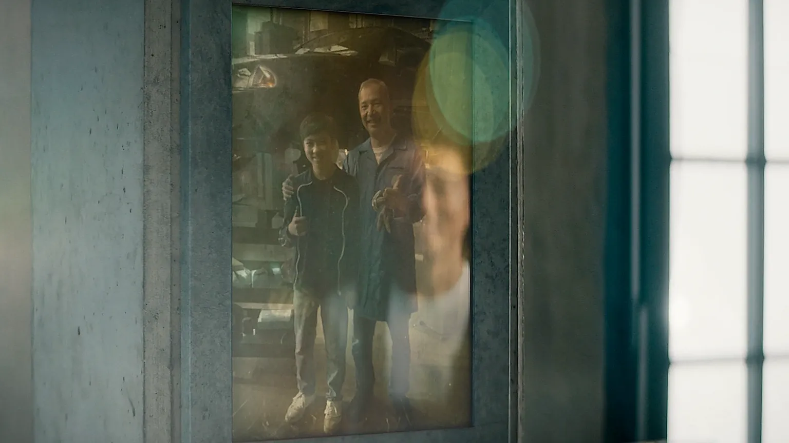 Altes Foto von Vater und Sohn in der Werkstatt als Erinnerung an gemeinsame Arbeit.