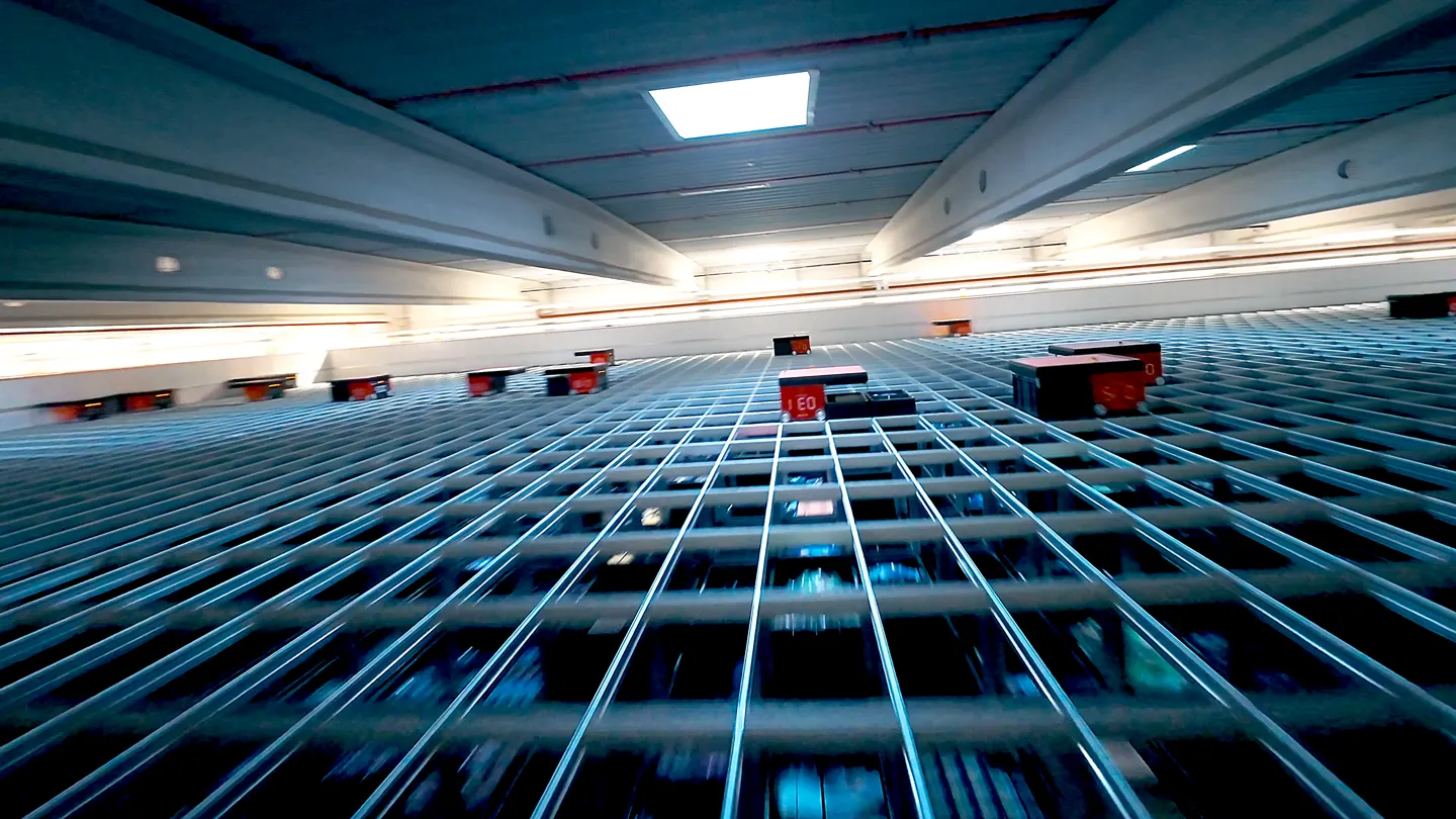 Kundenfilm Szene: Mehrere AutoStore Roboter bewegen sich auf einem Gitternetz für automatisierte Lagerlogistik bei Nobby – moderne Darstellung von Effizienz, Innovation und Logistikprozessen im Kundenfilm.