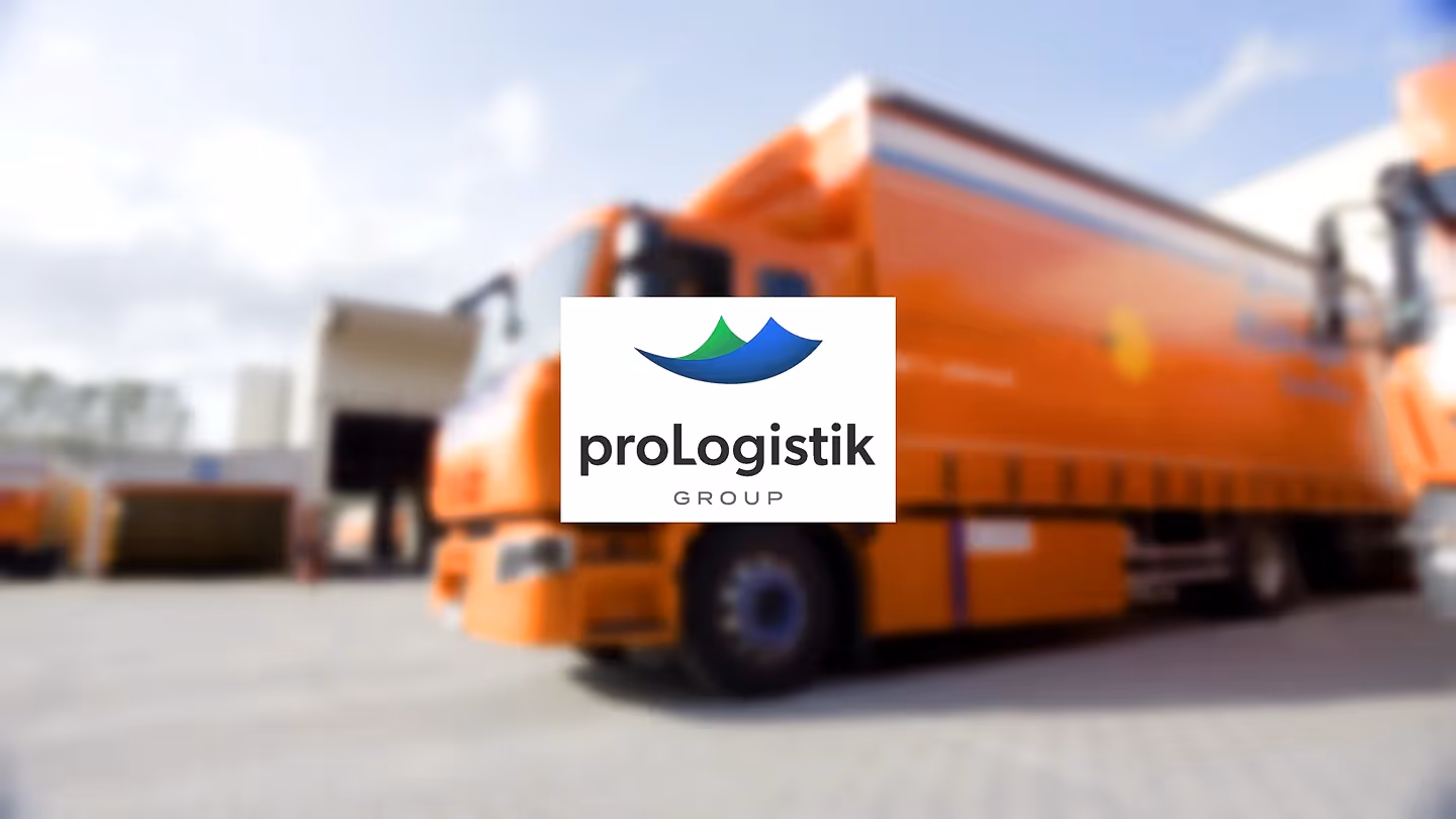 proLogistik Group Logo vor unscharfem Hintergrund mit orangefarbenem Lkw – visuelle Darstellung von Transport, Industrie und moderner Logistik in hochwertiger Unternehmenskommunikation und Filmproduktion.