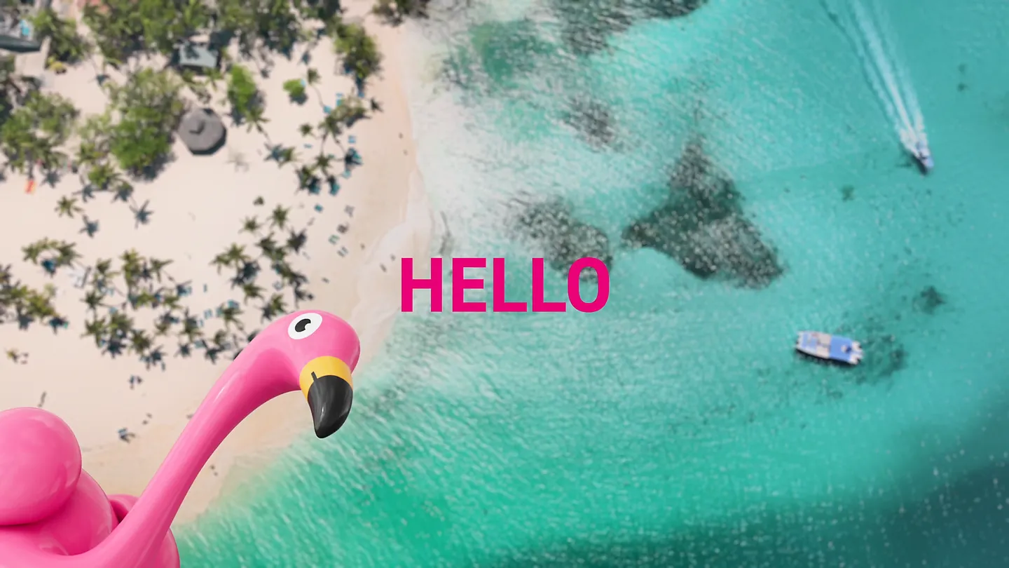 Luftaufnahme eines Strandes mit türkisfarbenem Meer, pinker Flamingo-Illustration und Schriftzug HELLO.