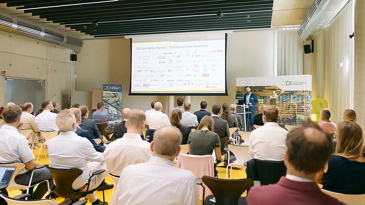 Teilnehmer beim CDI Summit in einer Konferenz, Vortrag zu Partnern und Dekarbonisierung der Industrie.