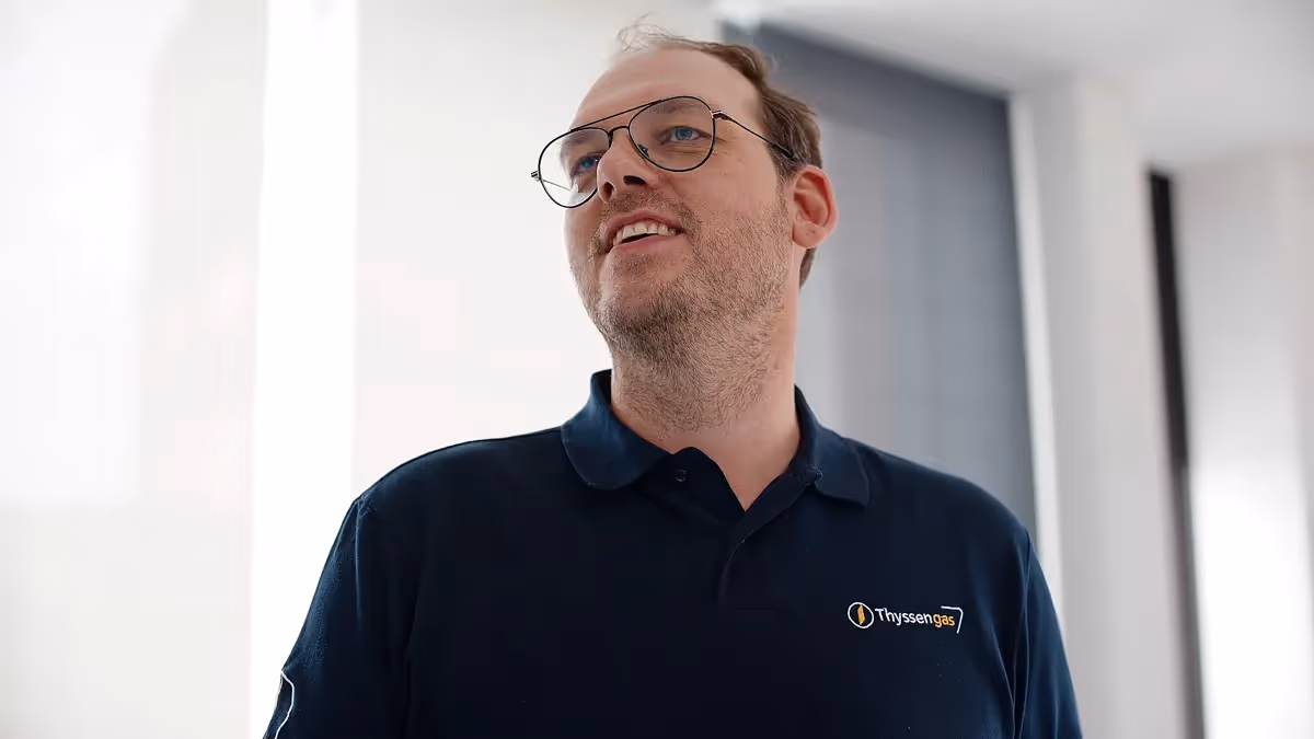 Ein Mitarbeiter in Unternehmenskleidung blickt motiviert nach vorne. Die Szene vermittelt Professionalität und Engagement – Teil eines modernen Kundenfilms oder Produktvideos zur authentischen Unternehmensdarstellung.